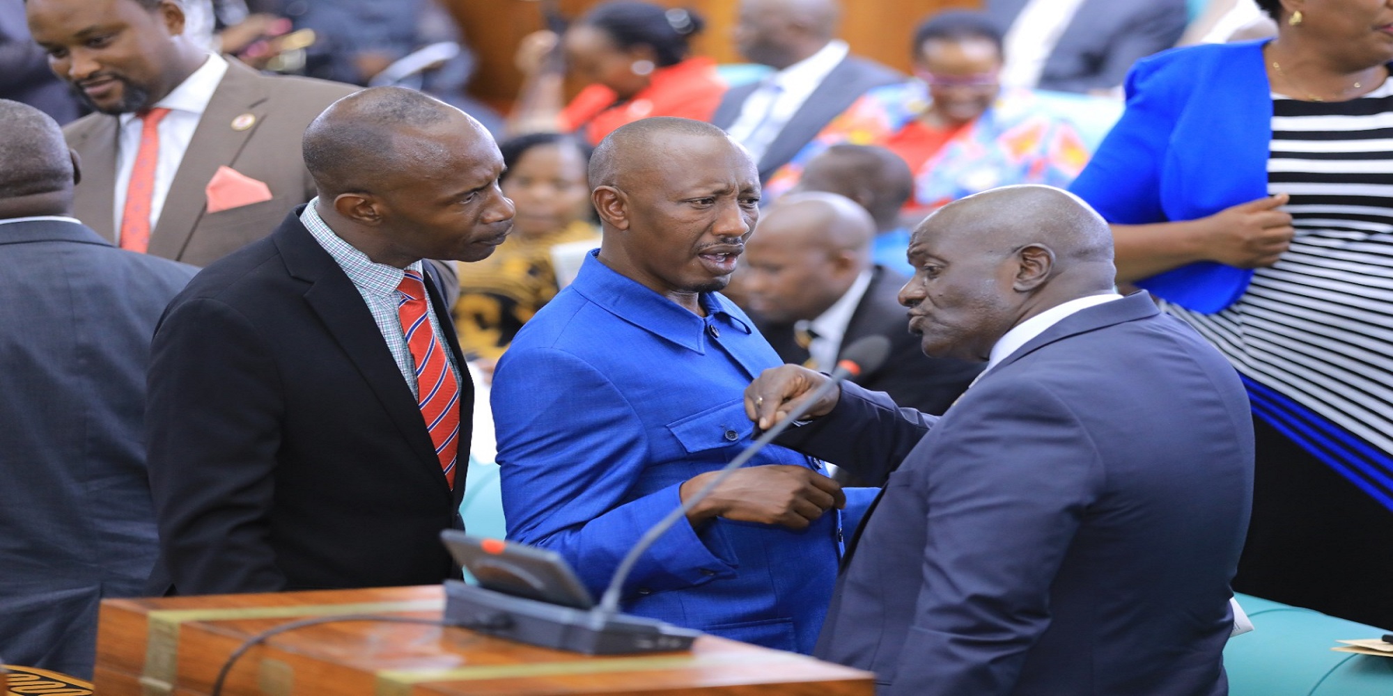 Works Minister, Gen Katumba Wamala (R) interacts with MPs before the House processed the supplementary request