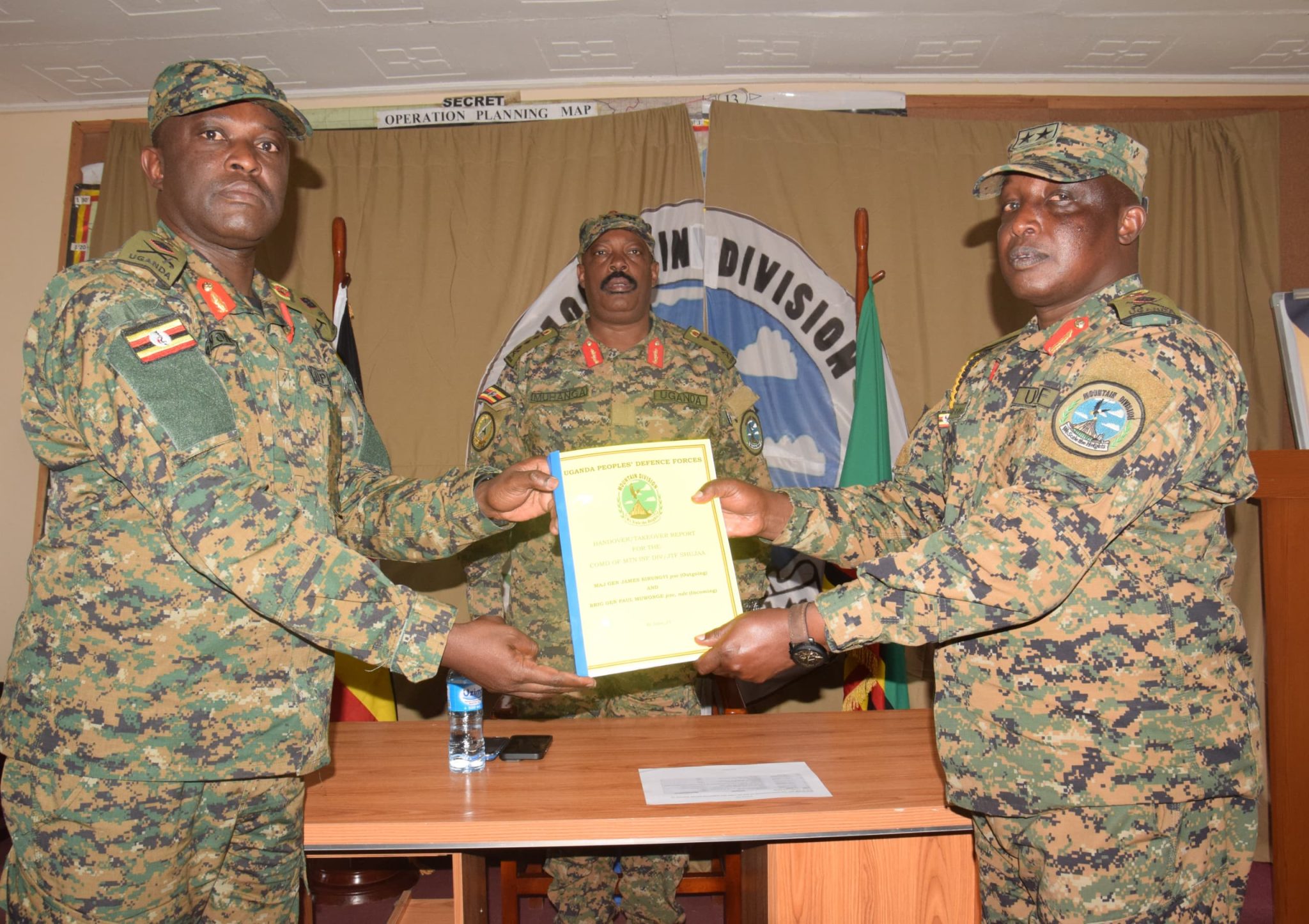 From-right-the-out-going-MTN-DIV-Comdr-Maj-Gen-James-Birungi-handing-over-a-report-to-the-incoming-MTN-DIV-Comdr-Brig-Gen-P-Muwonge-.-left-2048x1446