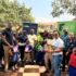 Some of the KCB staff pose for a photo with pupils from St.Jude Primary School as they hold some of the reading material donated by the bank