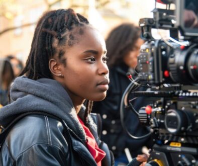 Young filmmaker operating professional camera on urban set