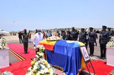 President Museveni paying his respect after laying a wreath on the casket containing the remains of King Oyo at Entebbe Airport on Friday. PPU Photo.