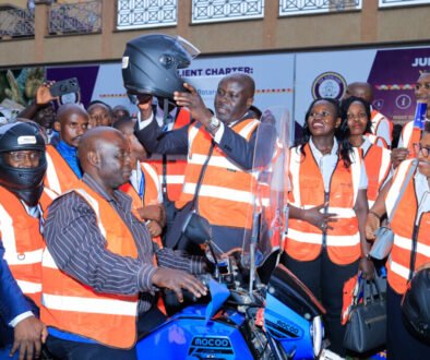 Rotary District 9213 Governor, Dr. Gerald Obai putting a helmet on a boda boda cyclist (1)