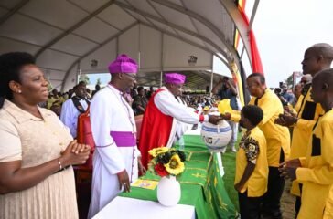 Prof Kamuntu presents the offertory basket to the Bishops during his thanksgiving in Sheema on Saturday. PPU Photo
