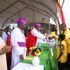 Prof Kamuntu presents the offertory basket to the Bishops during his thanksgiving in Sheema on Saturday. PPU Photo
